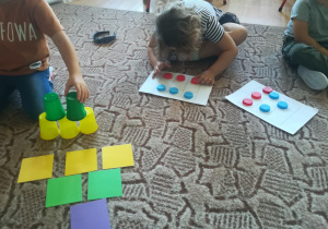 Dziewczynka zbudowała wieżę z kolorowych kubków